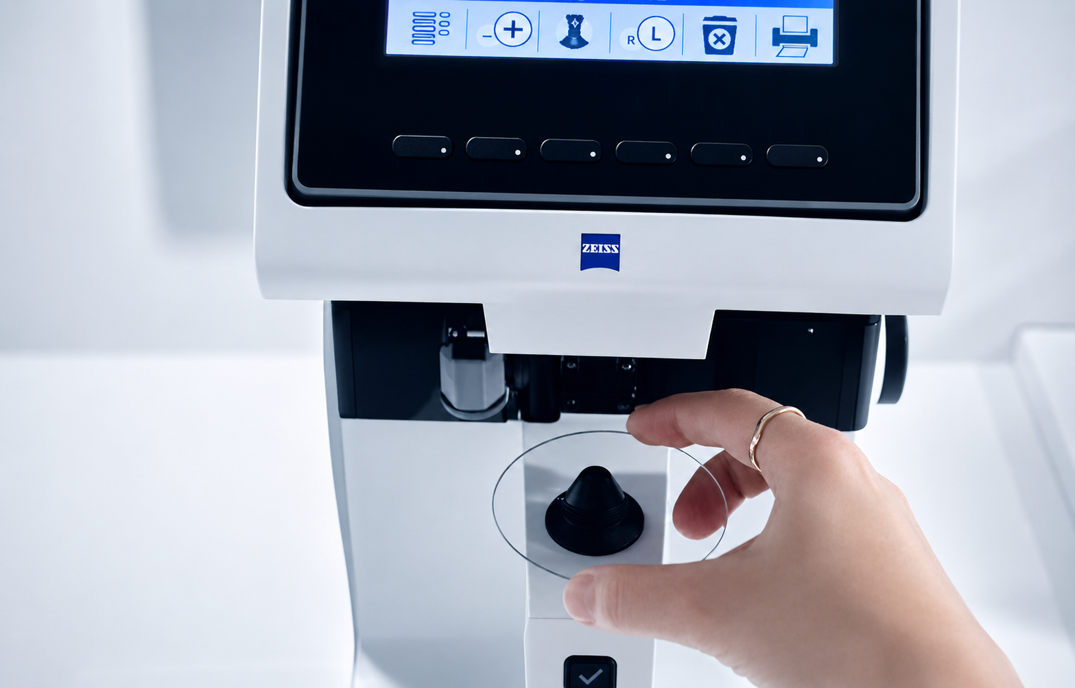 Die gläserne Manufaktur Hand hält eine runde Glasplatte vor ein weißes Messgerät mit Display und ZEISS Logo.